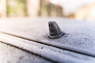 Car glass washer nozzle close-up covered with frost