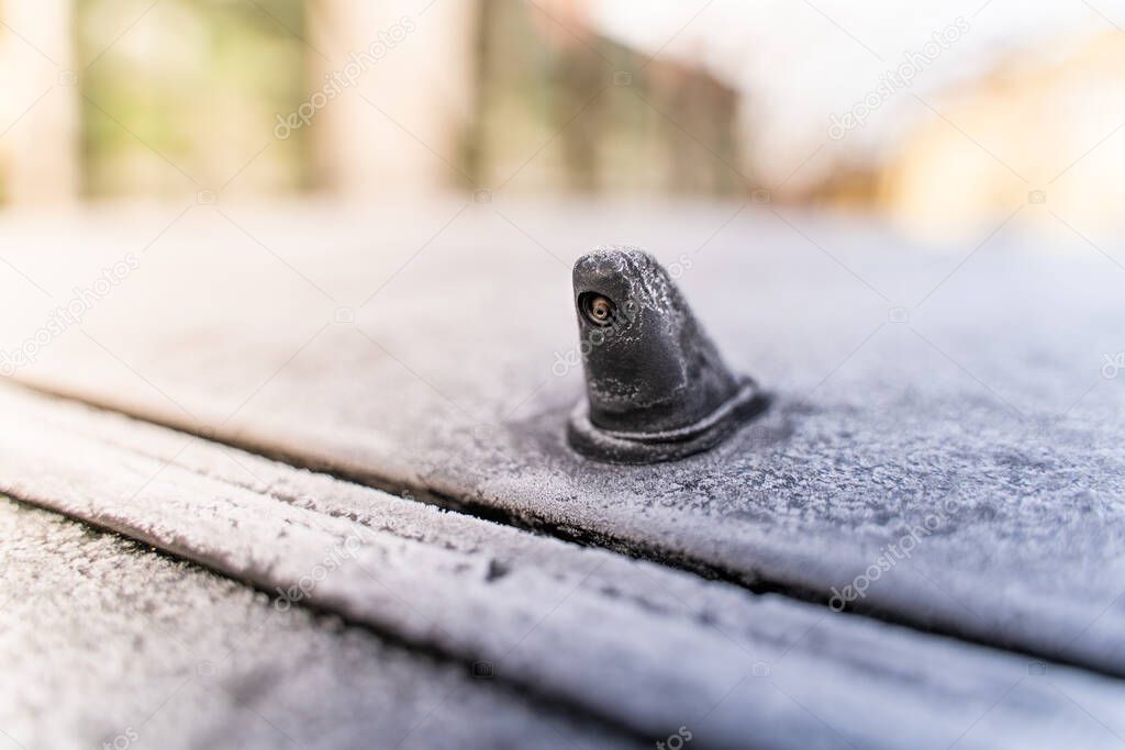 Car glass washer nozzle close-up covered with frost