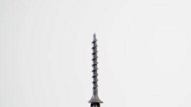 Siyah kendi kendine dokunan vida, beyaz arka planda bir Phillips tornavidasına mıknatıslanmıştır.