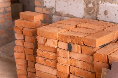 Yığılmış kırmızı tuğlalar beyaz gaz bloğunun arka planına karşı inşaat alanı