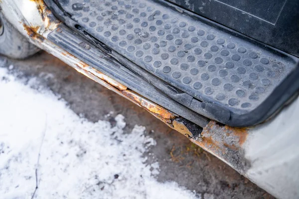 Rotten car footboard. Rusty driver\'s door sills. Corrosion of the car body after winter