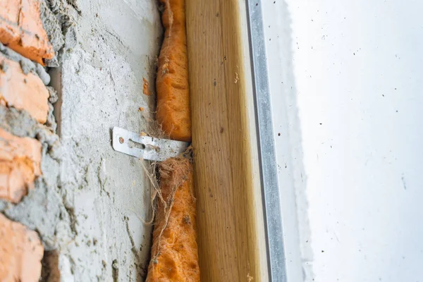 Havalı beton bloklardan bir duvara plastik bir pencere bağlamak. Örümcek ağında terk edilmiş bir inşaat alanının penceresi. Eski ve yeni takılan köpük
