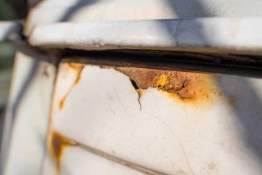 Beyaz bir arabanın kanadında paslı cepler var. Reaktörlerin kışın korunmasız bir araba üzerinde etkisi. çürük metal