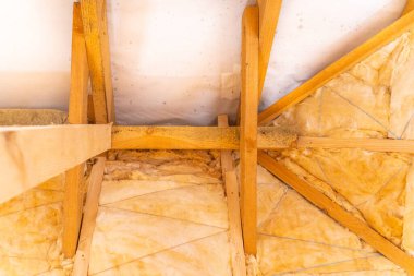Çatı sarı cam yünle yalıtılmış. Uygun çatı yalıtımı. Çatı yalıtımı öncesi ve sonrası fotoğraflar