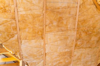 Çatı sarı cam yünle yalıtılmış. İplikle yalıtım astarı