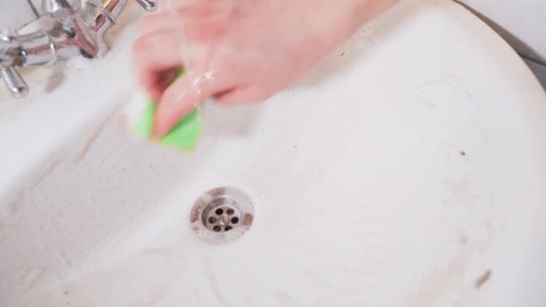 Eine Hand Wäscht Eine Schmutzige Weiße Keramikspüle Mit Einem Schwamm — Stockvideo