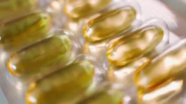 Balık yağı kapsüllü folyo tabağı yakın çekimde dönüyor. Yüksek kaliteli FullHD görüntüler