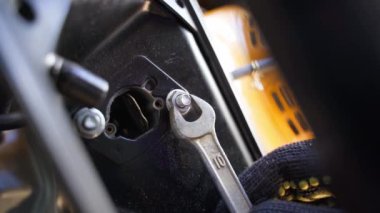 Açık uçlu bir anahtarla karbüratör kapağını sökmek. Benzin jeneratörünün vidasını sökmeye yakın çekim. Yüksek kalite 4k görüntü