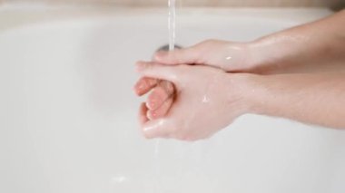 Banyoda akan suyun altındaki sabunları yakın planda yıkamak. Yüksek kalite 4k görüntü