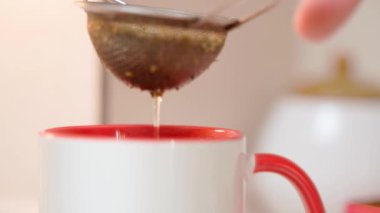 Bir fincan demlenmiş çay için yeşil çay yığınını sallıyor. Yüksek kalite 4k görüntü