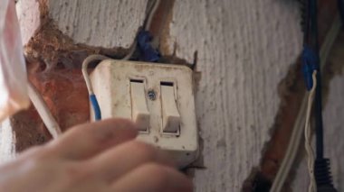 Parmak, köydeki eski evin kil duvarındaki eski ışık düğmesinin iki düğmesine sırayla basıyor. Yüksek kalite 4k görüntü