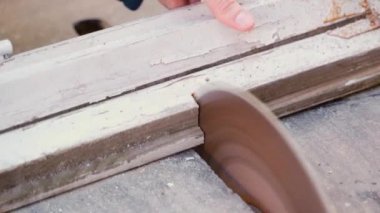 Old wooden window frames are sawn on a machine with a circular saw. High quality 4k footage