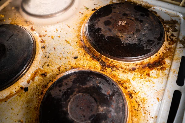 Çok ağır kirlenmiş eski mutfak elektrikli sobası yanmış kahverengi is ve yağ.