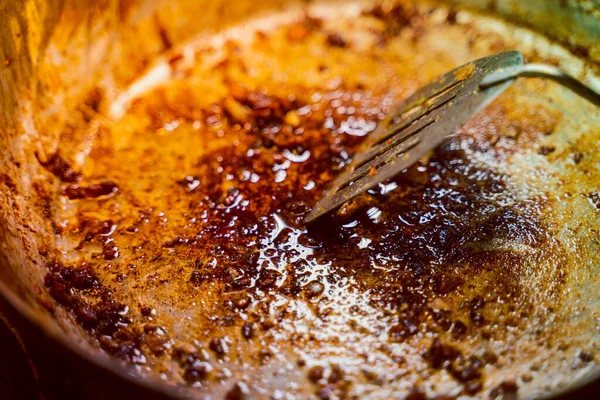 Eski metal kızartma tavası, yanmış yağ ve kurum.