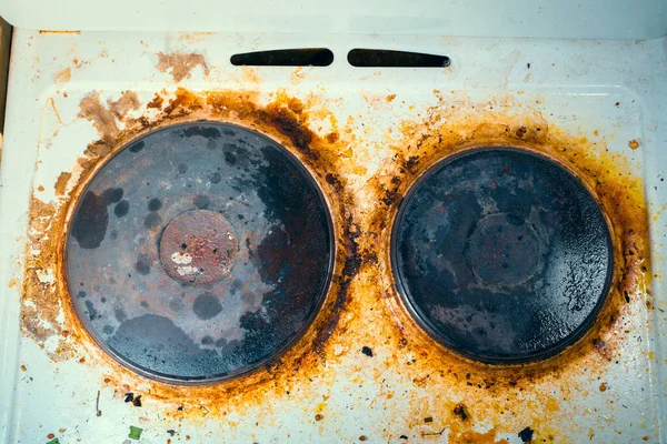 Old kitchen electric stove in heavy brown pollution and soot close-up, top view