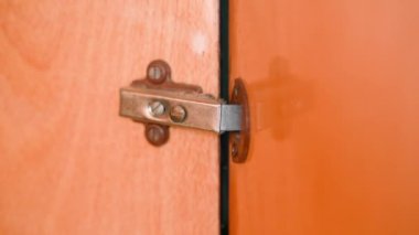 The work of the door hinge of an old wooden cabinet close-up. High quality 4k footage