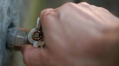 The hand opens the valve and water flows from the yard garden tap close-up. High quality 4k footage