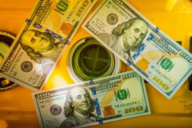 100 dolarlık banknotlar, deponun dolgu boynu yakınında. Yakından, en üstten.
