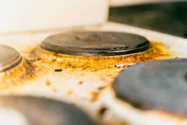 Old kitchen electric stove in heavy brown pollution and soot close up