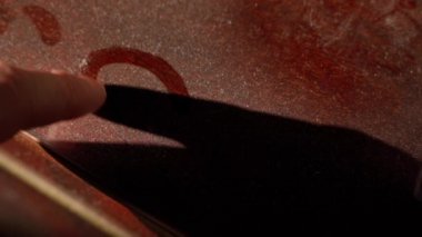 Finger draws a heart on a dusty brown surface close-up. High quality FullHD footage