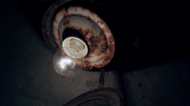 Light Bulb Screwed Rusty Ceiling Close Glows Dark Room High — стоковое видео