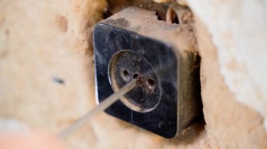 Elektrik prizinin kapağını söküp sökmek. Eski elektrik tesisatının tamiri. Kırsal kesimde elektrik kesintisi. Yüksek kalite 4k görüntü