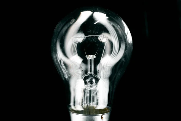 Glass light bulb close up on black background