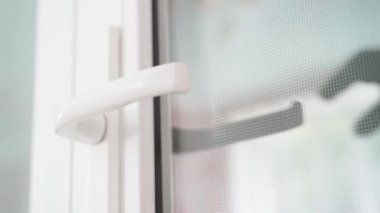 A black-gloved hand opens a blue plastic door. Black hand pulling the door handle in slow motion. High quality FullHD footage