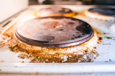 Çok ağır kirlenmiş eski mutfak elektrikli sobası yanmış kahverengi is ve yağ.