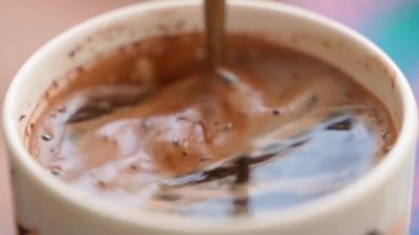 Close-up of stirring coffee with foam with a teaspoon in slow motion. High quality FullHD footage