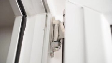 The work of the door hinge of a plastic door close-up. Opening and closing. High quality FullHD footage