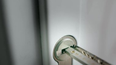 Slow uncertain insertion of a perforated key into the lock cylinder close-up. High quality FullHD footage