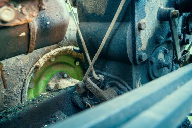 The power unit of the running gear of the walk-behind tractor. Wheel lock rods for turning on a tractor. Dirty unit with oil stains