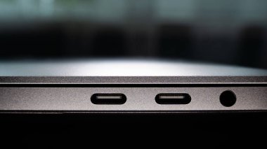 Side panel of a thin laptop with USB Type-C connectors for charging and file transfer and a 3.5 mm mini-jack for connecting headphones and speakers