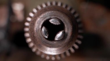 Old rusty drill chuck rotates close-up on a blurred background. Screwdriver chuck pliers for fastening nozzles and drills. Background or industrial action wallpaper. High quality FullHD footage