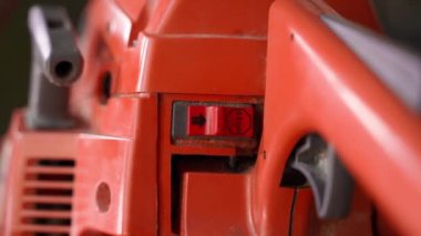 Old orange chainsaw close-up. Control elements of a gasoline saw. Smooth camera movement. High quality FullHD footage