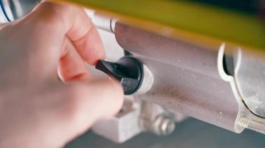 The hand unscrews the oil dipstick in the engine housing close-up. Checking the oil level in the sump of the generator. Scheduled engine maintenance. High quality 4k footage