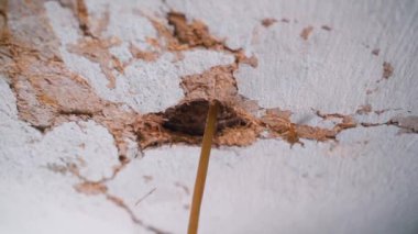 Kil tavanda bir delik, kabloyla birlikte. Çatıda ev yapımı vinç olan kırsal bir evin eski garajı. Eski bir evin harap olmuş duvarları. Deliğin etrafında düzgün bir kamera hareketi. Yüksek