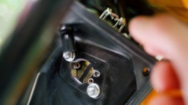 A hand checks the operation of the suction to adjust the air-fuel mixture for a cold start of the engine. The air damper of the carburetor of a gasoline electric generator close-up. Air regulation