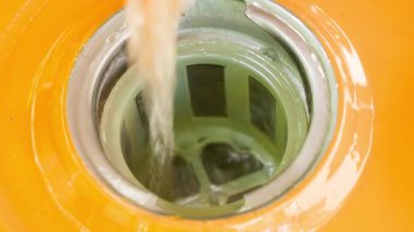 Fuel is poured into the fuel tank of a yellow gas generator from a plastic canister close-up. Refueling a gasoline generator. A jet of clear clean gasoline into the filler neck. High quality 4k