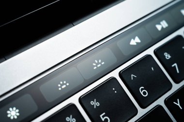 Kiev, Ukrayna - 9 Ağustos 2022: Dokunmatik çubuk elma macbook profosyoneli üzerinde klavye aydınlatma düğmeleri. Gri dizüstü bilgisayarda ek olarak küçük dokunmatik ekran