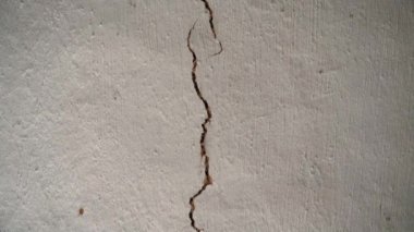 Eski bir evin tavanında büyük, uzun bir çatlak. Çatlamış yüzeye paralel kamera hareketi. Konutun bütünlüğü zarar görmüş, yapının acil durumu. Yüksek kaliteli FullHD görüntüler