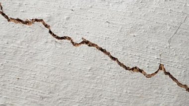 Eski bir evin tavanında büyük bir boşluk var. Düz kamera hareketi. Beyaz kil duvarda uzun bir çatlak. Yüksek kalite 4k görüntü