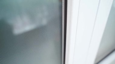 Camları donuk ve bembeyaz plastik gövdeli bir kapı. Plastik bir pencere üzerinde yakın çekim kamera dönüşü. Giriş kapısı beyaz. Yüksek kaliteli FullHD görüntüler