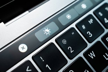 Kiev, Ukrayna - 9 Ağustos 2022: Dokunma çubuğu elma macbook profosyoneli üzerindeki ekran ışığı modu değiştirme tuşu. Gerçek Ton, dizüstü bilgisayarın gece gündüz modu