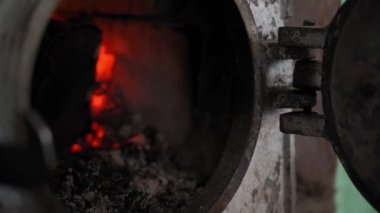 Bir el, yanan bir ateşle eski bir kırsal ocağın yuvarlak kapısını kapatır. Kışın odun ısıtma. Soğutma ve alternatif yakıt. Isı tasarrufu. Yüksek kalite 4k görüntü