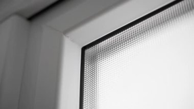 Karanlıkta plastik kapılı, opak camlı, çift camlı bir pencere. Plastik bir kutunun desenli penceresi. Pürüzsüz kamera hareketi. Beyaz ön kapılar. Yüksek kaliteli FullHD görüntüler