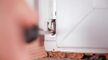 Plastik bir kapının menteşesini tornavidayla sökmek. Plastik pencere perhizleri ve mekanizmaları. Teçhizatın sökülmesi ve kurulumu. Yüksek kalite 4k görüntü