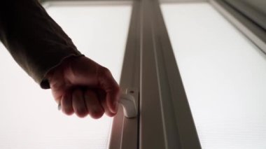 Kendinden emin bir adam kapıyı açar ve parlak bir odaya girer. Kapısı donuk bulutlu pencereli kapı. Yüksek kalite 4k görüntü