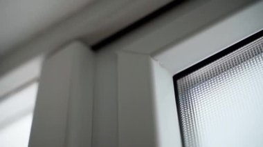 Karanlıkta plastik kapılı, opak camlı, çift camlı bir pencere. Plastik bir kutunun desenli penceresi. Pürüzsüz kamera hareketi. Beyaz ön kapılar. Yüksek kaliteli FullHD görüntüler